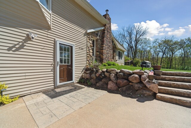 5780 Elvira, Pinckney, MI 48169 - doorway to property featuring a chimney and a patio area