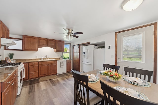 5780 Elvira, Pinckney, MI 48169 - kitchen featuring white appliances, a sink, a barn door, under cabinet range hood, and brown cabinets