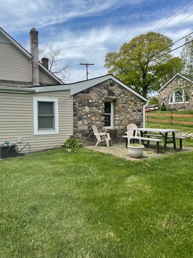 5780 Elvira, Pinckney, MI 48169 - rear view of property with a lawn, a chimney, and stone siding
