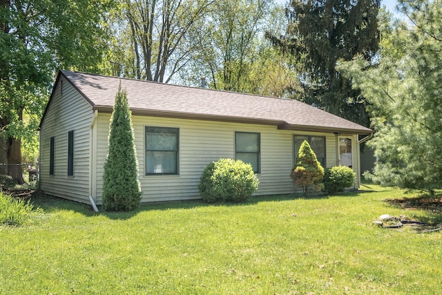 view of front of property with a front lawn and a shingled roof