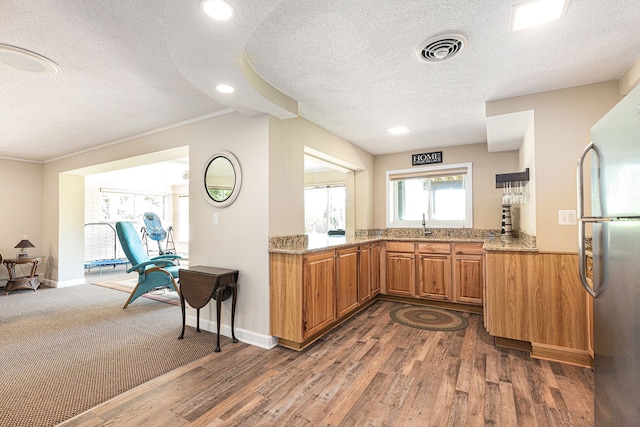 6305 N Shore Ct, West Bloomfield, MI 48324 - kitchen featuring a textured ceiling, freestanding refrigerator, dark wood-type flooring, light stone counters, and brown cabinets