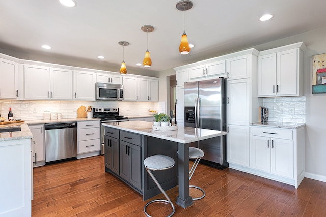 6305 N Shore Ct, West Bloomfield, MI 48324 - kitchen featuring stainless steel appliances, white cabinetry, dark wood-style flooring, decorative backsplash, and recessed lighting