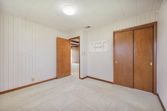 8607 Cochise Ct, Howard City, MI 49329 - unfurnished bedroom with carpet, a closet, and wallpapered walls