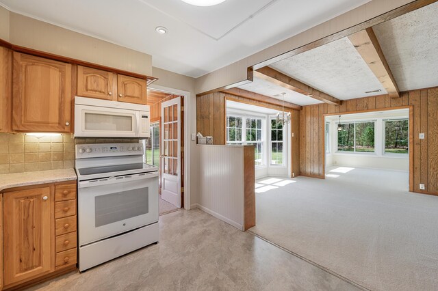 8607 Cochise Ct, Howard City, MI 49329 - kitchen featuring white appliances, plenty of natural light, decorative backsplash, beam ceiling, and wood walls
