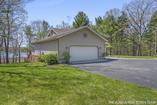 1087 Shore Walk Ln, Whitehall, MI 49461 - view of side of property featuring an attached garage, asphalt driveway, and a yard