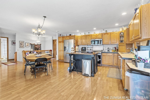 1087 Shore Walk Ln, Whitehall, MI 49461 - kitchen featuring stainless steel appliances, a sink, a center island, light wood-type flooring, and a chandelier