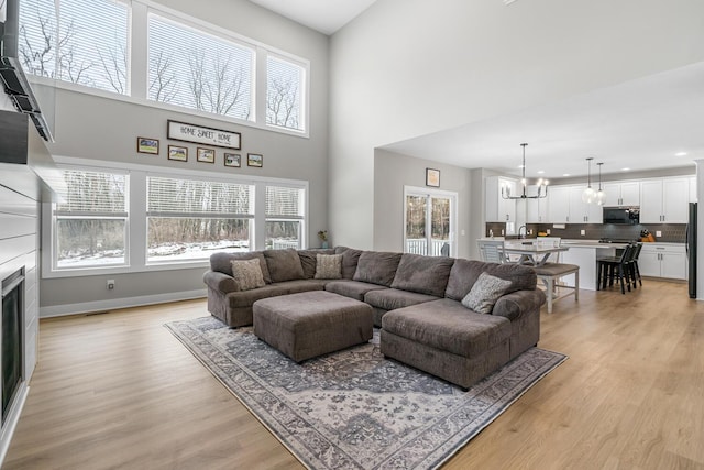 5414 Bradley Ct, Kalamazoo, MI 49009 - living area with healthy amount of natural light, a fireplace, light wood-style floors, a chandelier, and recessed lighting