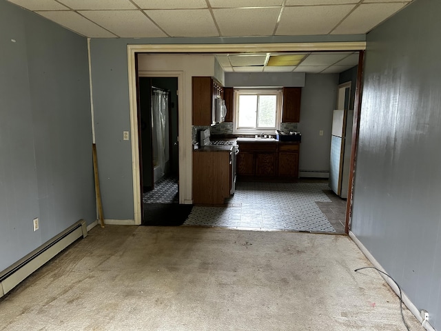 117 Hanover Ct, Hanover, MI 49241 - kitchen featuring white appliances, baseboard heating, a drop ceiling, dark countertops, and a baseboard radiator
