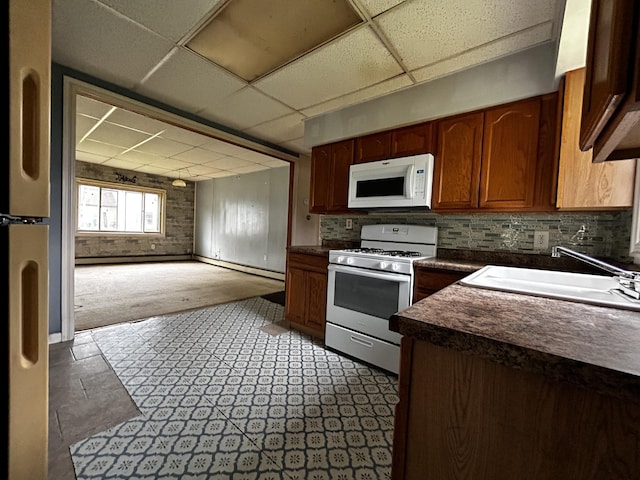 117 Hanover Ct, Hanover, MI 49241 - kitchen featuring white appliances, a paneled ceiling, dark countertops, carpet floors, and tasteful backsplash