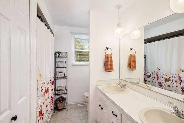 7055 N Center Rd, Mount Morris, MI 48458 - bathroom featuring toilet, double vanity, baseboards, and tile patterned flooring