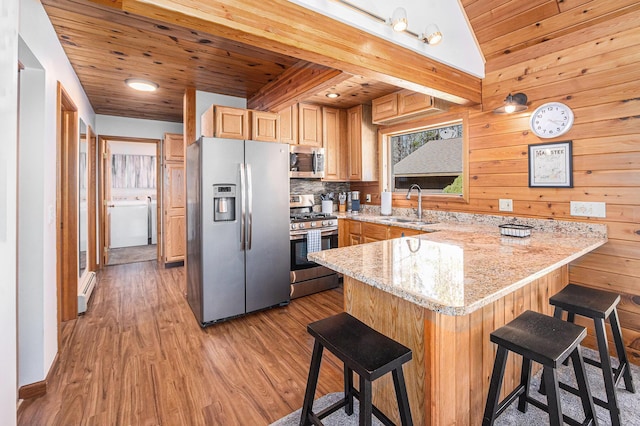 2526 Aikens Rd, Manistee, MI 49660 - kitchen with stainless steel appliances, a sink, a peninsula, wood ceiling, and light wood finished floors