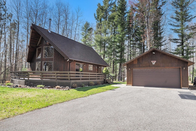 2526 Aikens Rd, Manistee, MI 49660 - view of home's exterior with a yard, a shingled roof, a wooden deck, and a garage