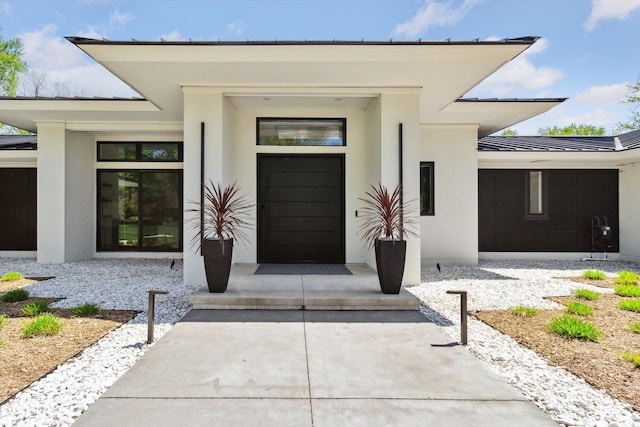 view of exterior entry featuring stucco siding