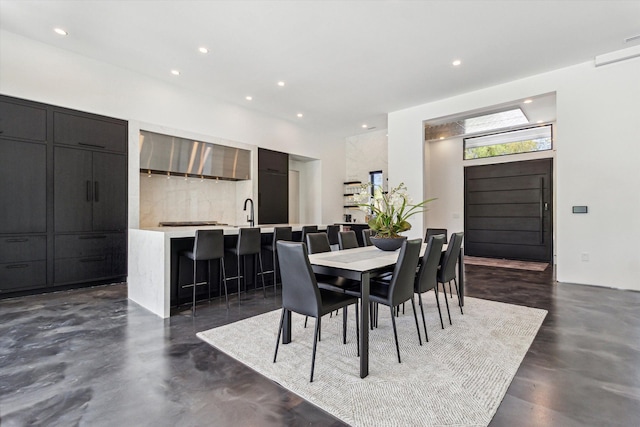 dining room featuring concrete floors and recessed lighting