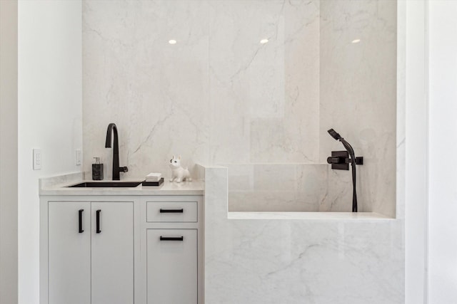 bathroom featuring vanity and a marble finish shower