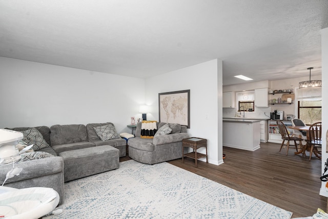 839 Rolling Meadows Dr, Quincy, MI 49082 - living area with dark wood-type flooring, baseboards, and a chandelier