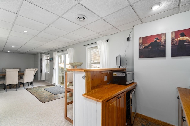 839 Rolling Meadows Dr, Quincy, MI 49082 - kitchen featuring beverage cooler, wood counters, a drop ceiling, stainless steel microwave, and baseboards