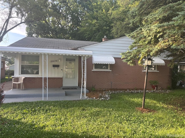 26176 Andover St, Inkster, MI 48141 - view of front facade featuring a porch, brick siding, and a front lawn