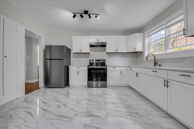 16585 Sunderland Rd, Detroit, MI 48219 - kitchen with appliances with stainless steel finishes, under cabinet range hood, a sink, light countertops, and light marble finish floors