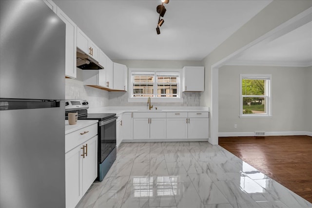 16585 Sunderland Rd, Detroit, MI 48219 - kitchen featuring freestanding refrigerator, range with electric stovetop, under cabinet range hood, light countertops, and a sink