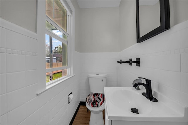 16585 Sunderland Rd, Detroit, MI 48219 - half bathroom with tile walls, toilet, a sink, wood finished floors, and wainscoting
