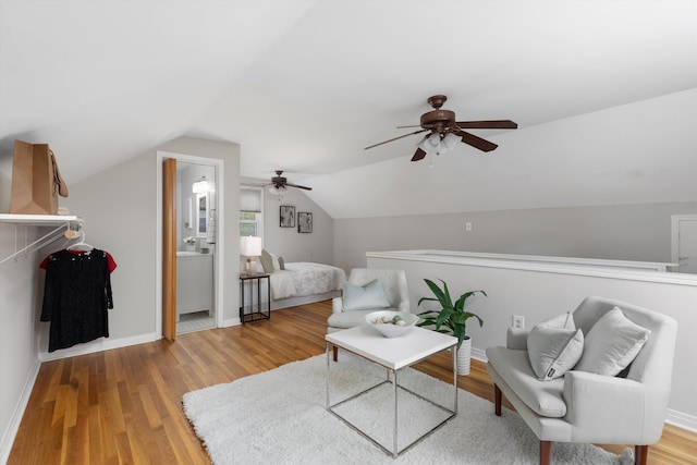 living area featuring a ceiling fan, light wood finished floors, lofted ceiling, and baseboards