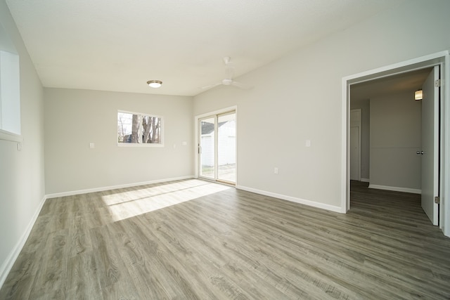 empty room featuring wood finished floors, baseboards, and ceiling fan