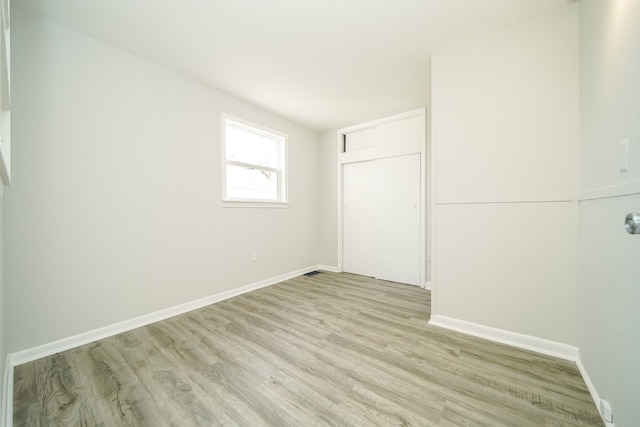 empty room featuring light wood-type flooring and baseboards