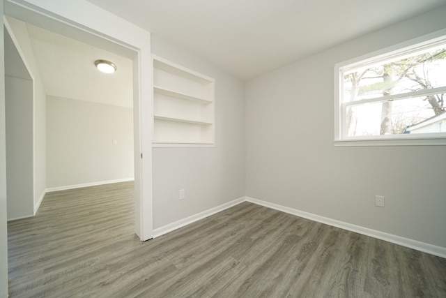 empty room featuring baseboards and wood finished floors