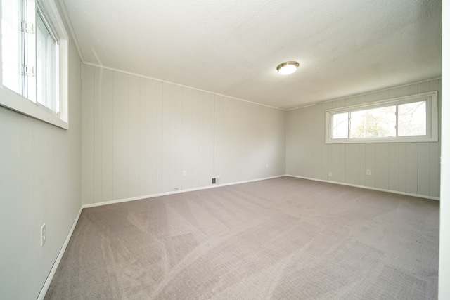 spare room featuring carpet and baseboards