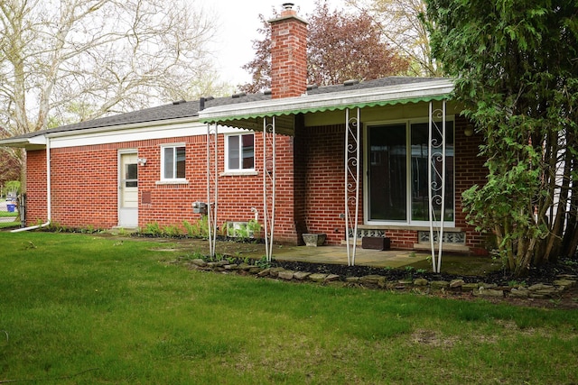 28407 Milton Ave, Warren, MI 48092 - back of house featuring a chimney, a yard, brick siding, and a patio