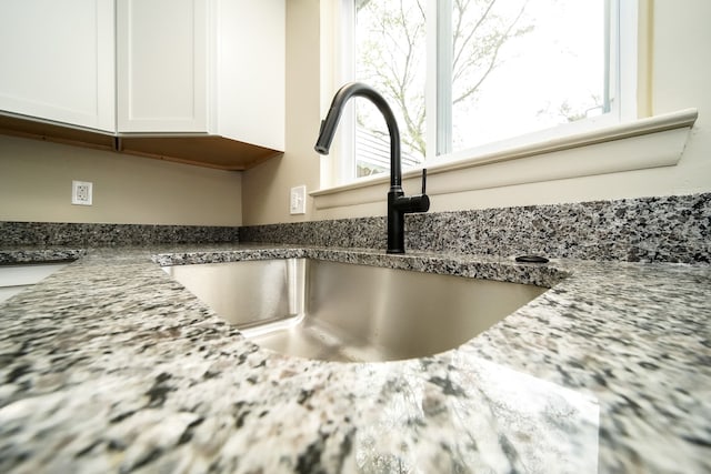 28407 Milton Ave, Warren, MI 48092 - kitchen view of a sink, white cabinetry, and dark stone counters
