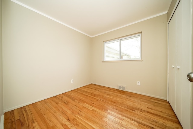 28407 Milton Ave, Warren, MI 48092 - unfurnished bedroom with light wood-style floors, a closet, baseboards, and ornamental molding