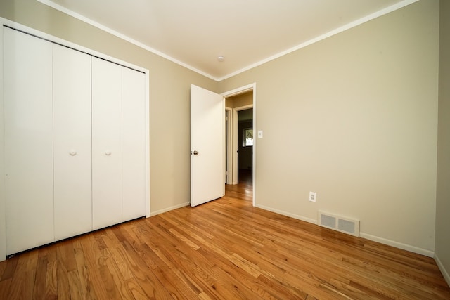 28407 Milton Ave, Warren, MI 48092 - unfurnished bedroom with light wood-style floors, crown molding, baseboards, and a closet