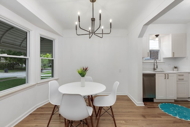 dining area featuring a chandelier, baseboards, and light wood-type flooring