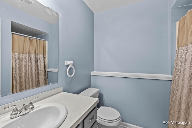 bathroom with toilet, vanity, and curtained shower
