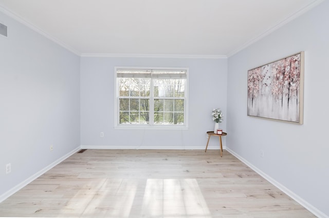 empty room featuring ornamental molding, wood finished floors, and baseboards