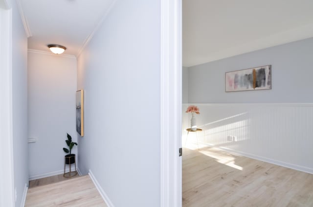 corridor with crown molding, wood finished floors, and baseboards
