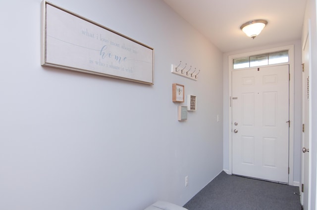 doorway with dark colored carpet