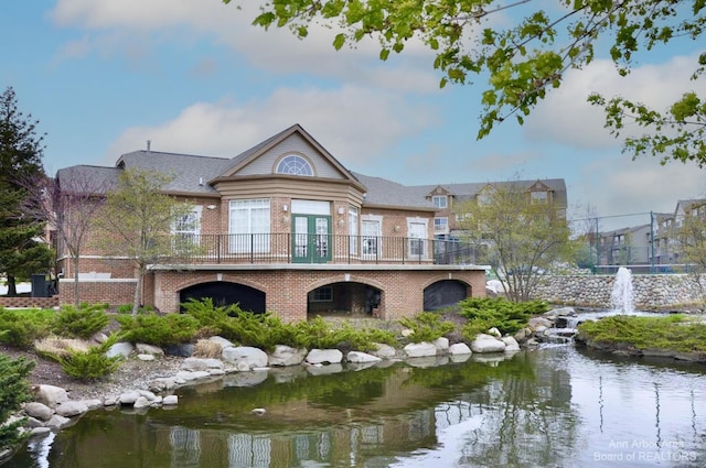rear view of property with brick siding and french doors