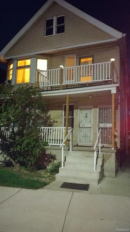 view of front facade with a balcony and covered porch