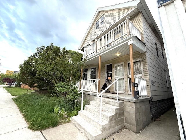 view of front of property featuring a balcony and covered porch