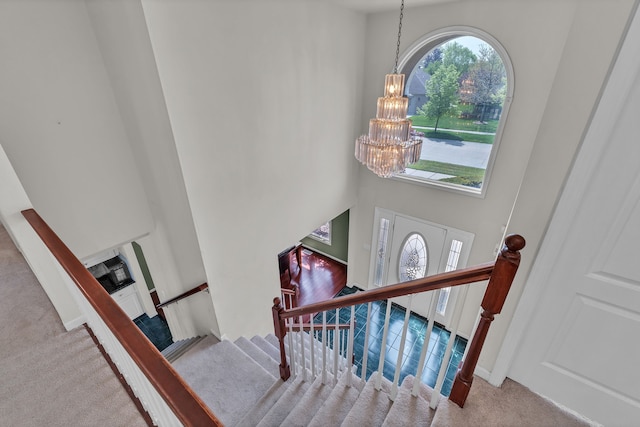 20261 Ramblewood Dr, Macomb, MI 48044 - stairs with carpet flooring, a chandelier, and a high ceiling