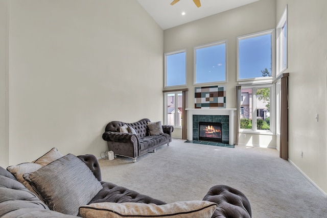 20261 Ramblewood Dr, Macomb, MI 48044 - carpeted living room with a high ceiling, ceiling fan, plenty of natural light, a tiled fireplace, and baseboards