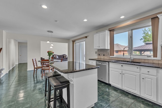 20261 Ramblewood Dr, Macomb, MI 48044 - kitchen with stainless steel dishwasher, a sink, tasteful backsplash, white cabinetry, and a kitchen island