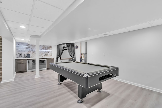20261 Ramblewood Dr, Macomb, MI 48044 - recreation room featuring wine cooler, a dry bar, a paneled ceiling, light wood-style flooring, and baseboards