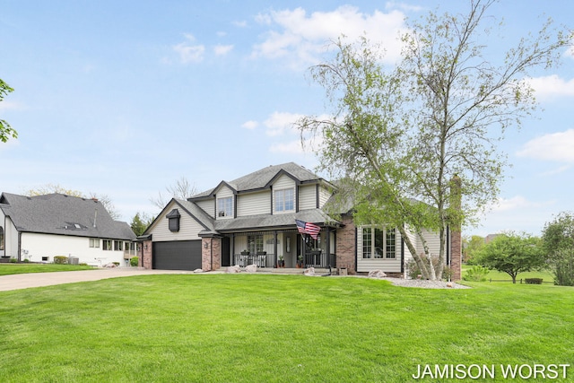 traditional-style home featuring concrete driveway, brick siding, a front yard, and a garage