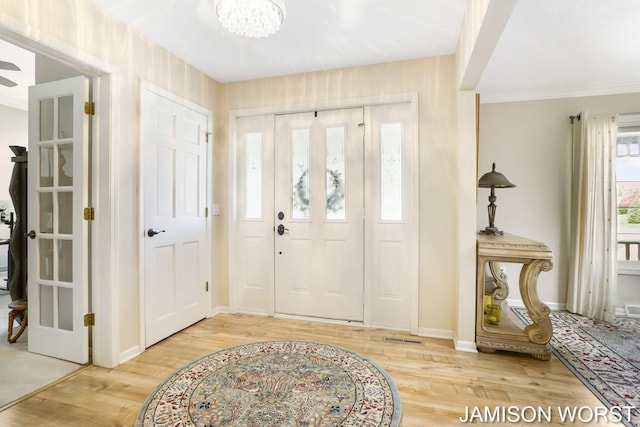 foyer entrance featuring wood finished floors, baseboards, and a chandelier