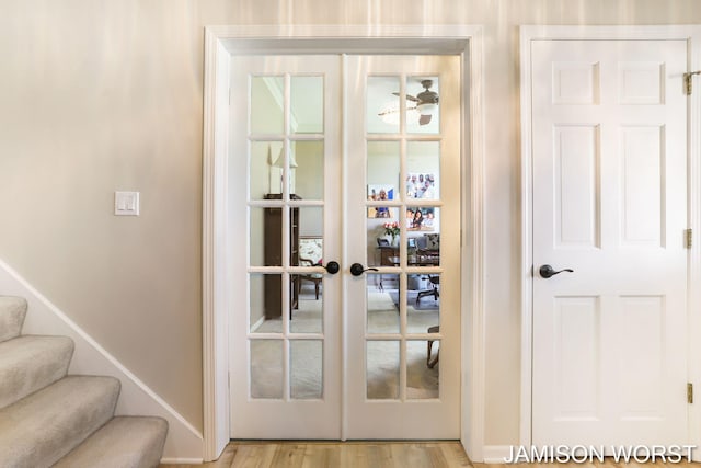 entryway featuring baseboards, stairway, light wood-type flooring, and french doors