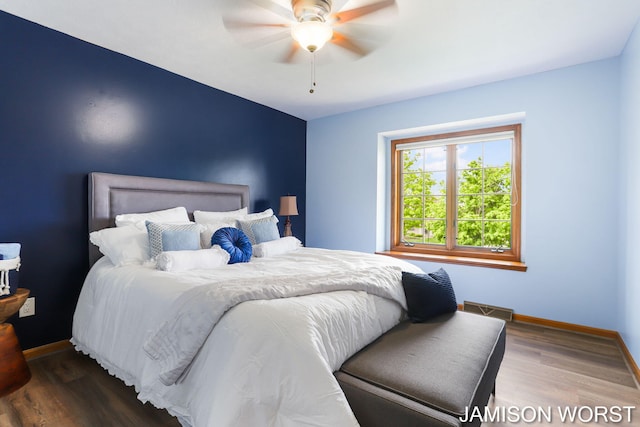 bedroom with baseboards, wood finished floors, and ceiling fan
